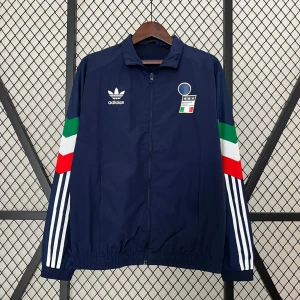 Mörkblå vindjacka från Adidas - Säljer en mörkblå vindjacka från Adidas med Italiens flagga på ärmarna och ett emblem på bröstet. Jackan har dragkedja och vita ränder längs ärmarna. Perfekt för sportiga tillfällen!