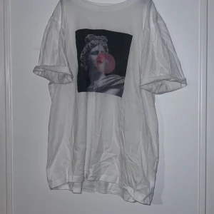 Vit t-shirt med konstmotiv från STAY - Säljer en vit t-shirt från STAY med ett coolt konstmotiv på framsidan. T-shirten har korta ärmar och en avslappnad passform. Perfekt för en stilren och modern look.