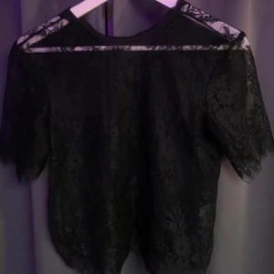 Svart spetsblus - Säljer en jätte fin svart spetsblus med korta ärmar köpt från plick för något år sedan i storlek S. Aldrig använt själv eftersom att den inte kommer till användning men jätte bra skick, ser ut som ny. Passar bra till både jeans och kjol.  Köpt för 150kr på plick