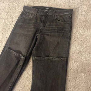 Svarta jeans från Replay - Snygga svarta jeans från Replay med klassisk femficksdesign och knappgylf. De har en stilren look med diskreta detaljer och en bekväm passform. 