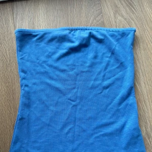 Blå tubtopp från NA-KD - Säljer en fin blå tubtopp från NAKD. Perfekt för sommaren. Den är i lite tjockare material så man behöver ingen bh under. Använd fåtal gånger då den inte passar mig längre🙌