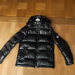 Moncler Maya - Säljer en snygg svart pufferjacka från Moncler. Använd i 4 månader ingen syn på användning 10/10. Säljer för att jag vill bli av med den så snabbt som möjligt då jag köpt en nya jacka till våren.