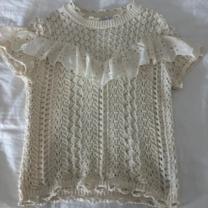 Topp från Zara - Säljer denna fina beiga stickade tröjan ifrån Zara med volanger, i storlek S. Den är i mycket bra skick och knappt använd. 