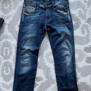 Mörkblå replay byxor  - Snygga mörkblå jeans med en klassisk femficksdesign och diskreta sömmar på bakfickorna. Perfekta för en stilren look.