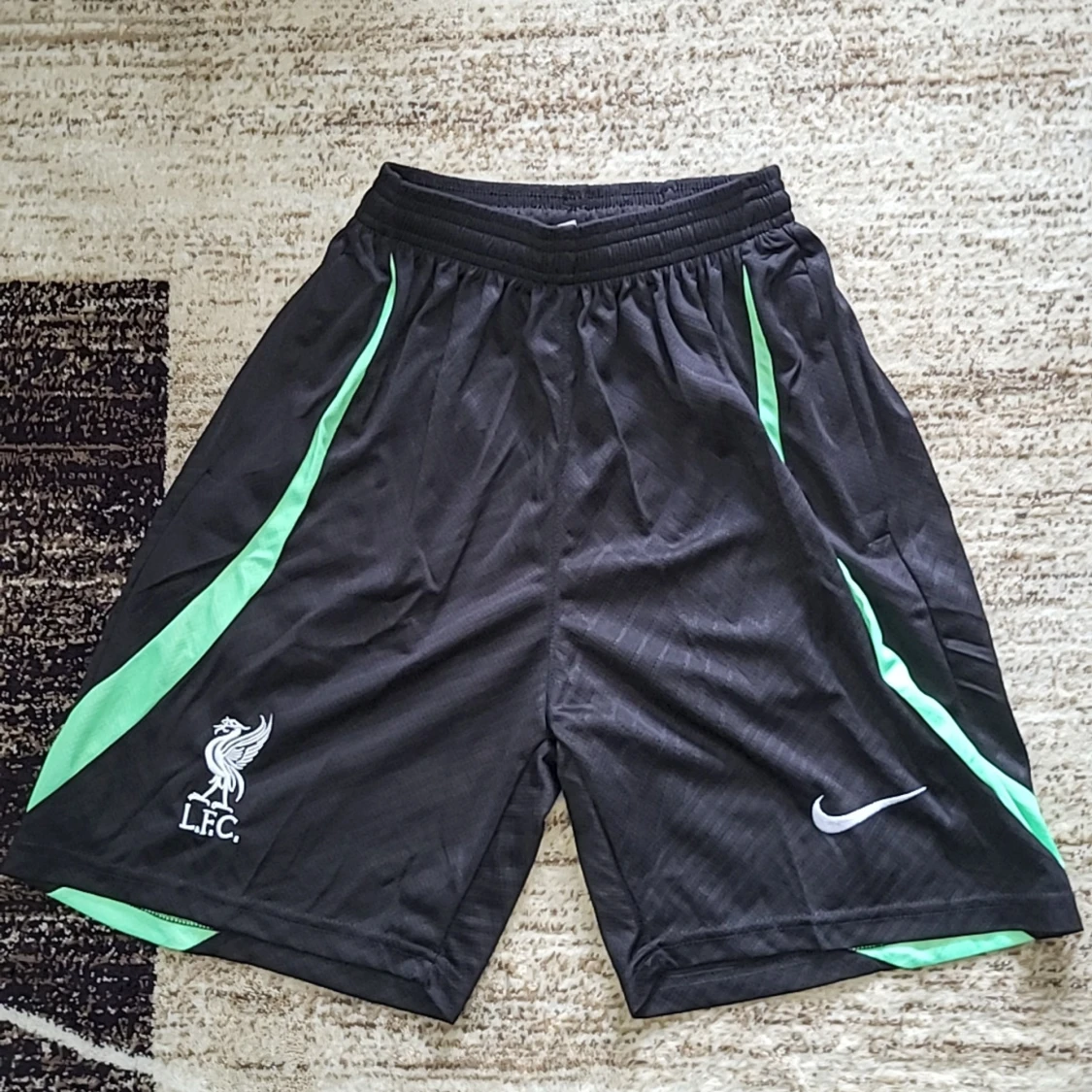 Svarta sportshorts från Nike med gröna detaljer