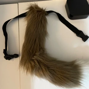 Svans - Säljer en ny svans som har ett bälte och som är strechigt. Svansen är i färgen beige med en vit topp. Svansen kan man ändra form på hur man vill❤️