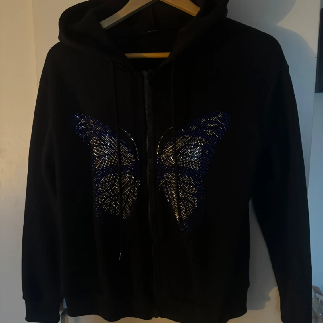 Svart hoodie med fjärilsdetalj