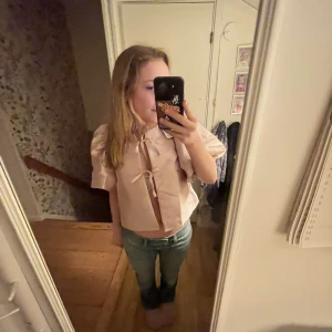 Rosa blus med puffärmar - Säljer en söt rosa blus med puffärmar och knytband, köpte fel storlek. Blusen är i storlek XS, men skulle säga att den passar XS-M🌸