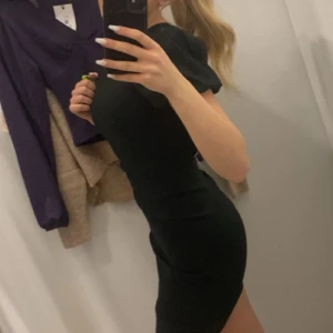 Svart klänning från Zara - Snygg svart klänning från Zara med korta puffärmar och en figurnära passform. Perfekt för en kväll ute eller en speciell tillställning. Klänningen har en elegant och tidlös design som passar många tillfällen.