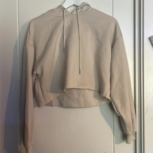 Beige croppad hoodie från FB Sister - Säljer en beige croppad hoodie från FB Sister. Den har en justerbar huva med dragsko och långa ärmar. Perfekt för en avslappnad stil. 🧥