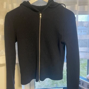 Marinblå ribbad tröja med dragkedja - Säljer en stilren marinblå ribbad tröja med dragkedja framtill. Den är använd 1-2 gånger och inga defekter. Den har långa ärmar och en huva. Passar bra till allt. Den har en tajt passform. 