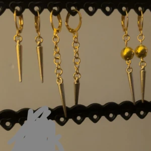 Guldörhängen med spetsdetaljer - Snygga guldörhängen med hängande spetsdetaljer. Två olika stilar: en med enkla spetsar och en med kulor och spetsar. Perfekta för att ge en edgy touch till din look. Ett par för 50kr