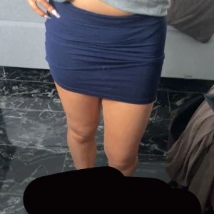 Mörkblå kortkjol - Snygg mörkblå kortkjol med tight passform. Perfekt för en stilren look. Kjolen är enkel och utan mönster, vilket gör den lätt att matcha med olika toppar.