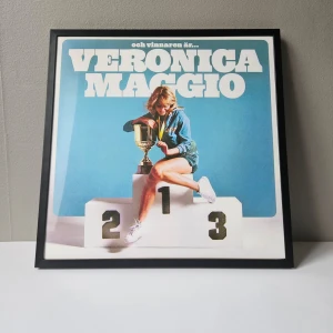 Veronica Maggio - Albumaffisch, 31.5x31.5cm - Veronica Maggio - Och vinnaren är... albumaffisch, 31.5x31.5cm  Helt ny - Passar bra i IKEAs tavelram Lomviken!  Skickas i papprulle - Ramen ingår inte!