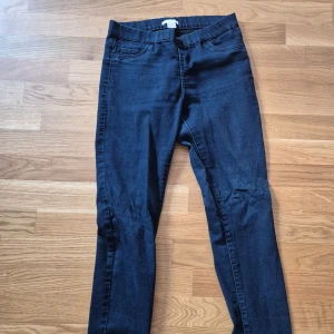 Mörkblå jeansbyxor - Snygga mörkblå jeansbyxor med en klassisk design. De har en smal passform och är perfekta för en stilren look. Byxorna har fickor både fram och bak samt en knapp- och dragkedjestängning.