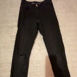 Svarta jeans från LAB Industries - Snygga svarta jeans från LAB Industries med en klassisk femficksdesign. De har en knapp och dragkedja framtill och är tillverkade i ett hållbart denimtyg. Perfekta för en stilren look. De är i storlek 152 för barn.