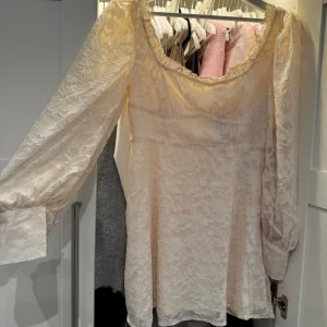 Ljusbeige spetsklänning med puffärmar - Romantisk ljusbeige klänning med vacker spets och långa puffärmar. Klänningen har en feminin, något lös passform och fyrkantig ringning. Perfekt för vårens och sommarens tillfällen. Modell: Mini. Prislapp finns även kvar, helt oandvänd🎀 Nypris 699 säljer nu för 399