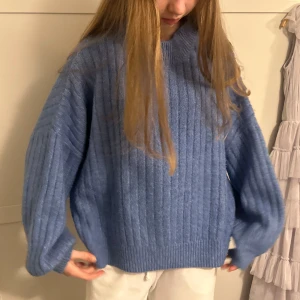Blå stickad tröja från Even&Odd - Säljer en blå stickad tröja från Even&Odd med ribbat mönster. Tröjan har lång ärm och en avslappnad passform, perfekt för kyliga dagar. Enkel och stilren design som passar till mycket.