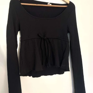 Svart långärmad topp med knyt  - En svart blus, oanvänd