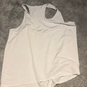 Vit linnetopp från H&M Move - Säljer en vit linnetopp från H&M Move i storlek L. Perfekt för träning eller varma dagar, med klassisk racerback och mjukt, lätt material som andas. Enkel och stilren design som passar till mycket.
