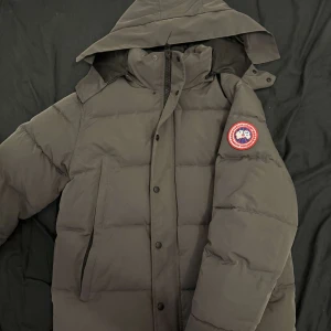 Canada Goose - Denim Tears dark blue hoodie features a relaxed, oversized fit with high-quality cotton fabric. It often includes unique embroidery or prints inspired by African American culture, along with an adjustable drawstring hood and ribbed cuffs for a stylish, comfortable look.  