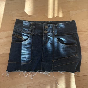 Mörkblå jeanskjol  - Säljer en mörkblå jeanskjol då den inte passar mig så bra. Skulle tro att midjemåttet är ca 38 cm rakt över. 