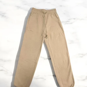 Beige/brun mjukisbyxa – superfin & bekväm (S/M) - Säljer en jättefin mjukisbyxa i beige/brun ton – stilren färg och otroligt skön att ha på sig. Perfekt för vardag, hemmamys eller en avslappnad outfit. Passar dig som har storlek S eller M – mjuk och stretchig i midjan.