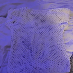 Vit stickad kortärmad tröja - Säljer en vit stickad tröja med korta ärmar. Tröjan har en luftig och grovstickad design som passar perfekt till varmare dagar. Enkel och stilren modell som är lätt att matcha med olika outfits.