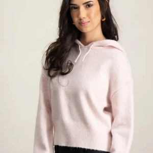 Ljusrosa hoodie med huva - Mysig ljusrosa hoodie med huva och dragsko. Tröjan har långa ärmar och ribbad nederkant, perfekt för en avslappnad stil. Passformen är något loose och materialet känns mjukt mot huden.