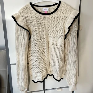 Vit stickad tröja med volang - Säljer en söt stickad tröja med volang, använt fåtal gånger så i princip i nyskick! Passar xs/s