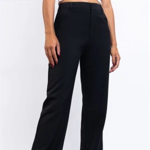 Svarta kostymbyxor med rak passform - Snygga svarta kostymbyxor med hög midja och raka ben. Perfekta för en stilren look. Storlek 34 längd 30💕 skriv gärna innan ni trycker på köp