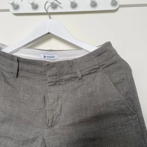 Gröna linneshorts från Dondup - Exklusiva gröna shorts från Dondup i ett svalt linnematerial. Klassisk design med bälteshällor, fickor fram och bak samt knapp- och dragkedjestängning. Perfekta för varma dagar och stilrena outfits. Mått: midja 74 cm, längd utsida 47 cm, längd insida 27 cm