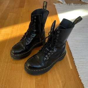 Svarta Dr. Martens Jadon boots med platå - Säljer ett par klassiska svarta Dr. Martens Jadon boots med snörning, dragkedja på sidan och kraftig platåsula.   Fräscha men använda! Mindre slitningar som syns på bild.   Nypris vid inköp: 2500 kr