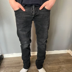 Replay jeans  - Säljer ett par svarta Replay Grover jeans med klassisk femficksdesign och Replay-logga på bakfickan. Jeansen har normal passform och är tillverkade i ett mjukt denimtyg. Perfekta för dig som gillar stilrena och bekväma jeans.