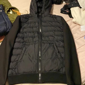 Cardigan  - Säljer en svart cardigan  med huva och dragkedja. Jackan har långa ärmar och ribbade muddar. Perfekt för kyligare dagar. Sitter bra på mig som är 171