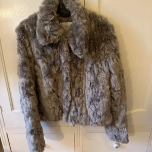 Finaste pälsjackan! - Säljer en superfin grå pälsjacka ifrån vila som knappt är använd. 