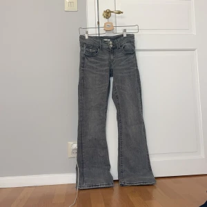 Grå bootcut jeans - Säljer ett par snygga grå bootcut jeans från Ginatricot.De är i storlek 158/164.De har en klassisk femficksdesign och är i ett mjukt och bekvämt denimtyg. Perfekta för både vardag och fest! Lite slitna vid benen
