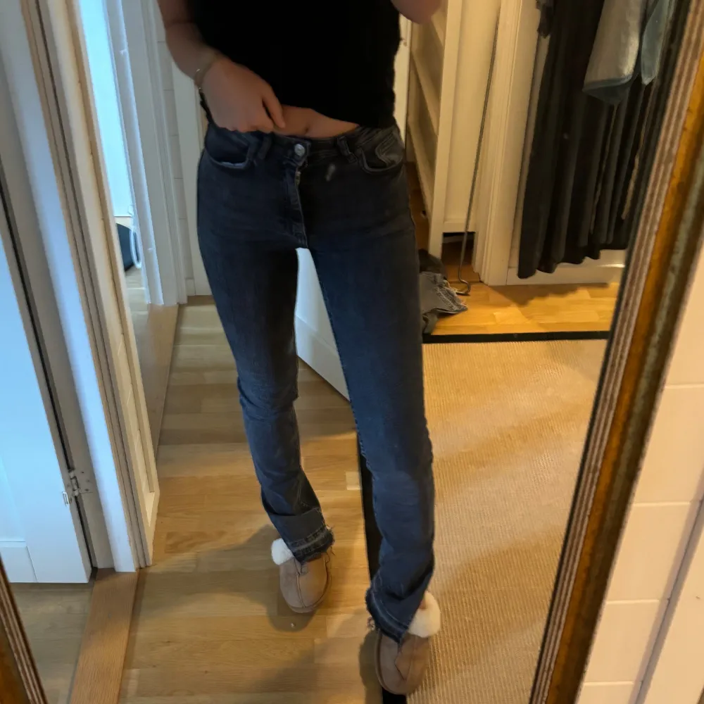 Säljer ett par grå/svarta jeans i slim fit. De är högmidjade och har en klassisk femficksdesign med knappar och dragkedja framtill. Perfekta för både vardag och fest! . Jeans & Byxor.