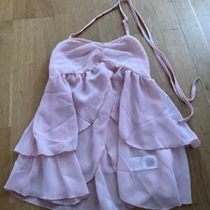 Rosa volang topp - En snygg volangtopp med snöring runt halsen. Den är helt ny och aldrig använd