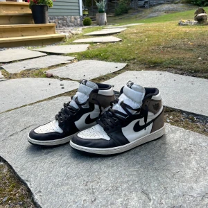 Jordan 1 mochas - Sjukt snygga jordans som kostar skjortan nya. Köpte dessa på GOAT för cirka 5000kr. Idag är de tyvärr för små för mig. utan några skador och små tecken på användning som att de är lite creasade som de flesta skor.