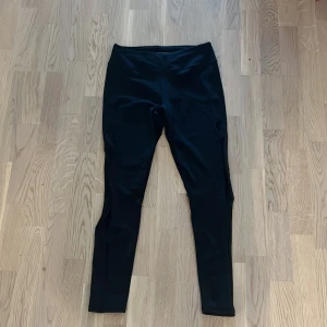 Svarta leggings - Säljer ett par svarta träningsleggings från Victora’s Secret Sport i stretchigt material. De har en meshdetlj längs båda sidorna på benen som sträcker sig till mitten på låren. Använda fåtal gånger