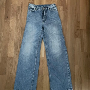 Jeans - Blåa jeans från Monki. Knappt använda! Sitter snyggt tight upptill och vidare nedtill! Storlek 24.