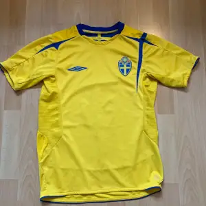 Sverige 2005/06 hemmatröja med Ekgrund på ryggen. Den är bra skick och är en mycket värdefull retro tröja. Det finns lite problem då (som ni ser på bilderna) har trycket i några ställen börjat att lossna men det syns ändå. Pris kan diskuteras.