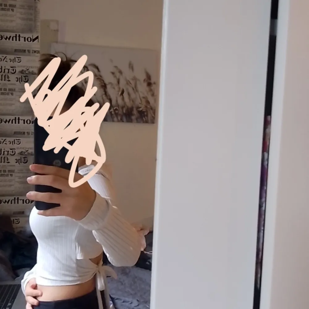 Säljer en superfin vit ribbad topp från PrettyLittleThing. Den är croppad och har långa ärmar, perfekt för en stilren look. Toppen har också knytband i sidan som ger en snygg detalj. Passar perfekt till både vardag och fest!. Yläosat.