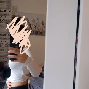 Vit ribbad croppad topp - Säljer en superfin vit ribbad topp från PrettyLittleThing. Den är croppad och har långa ärmar, perfekt för en stilren look. Toppen har också knytband i sidan som ger en snygg detalj. Passar perfekt till både vardag och fest!