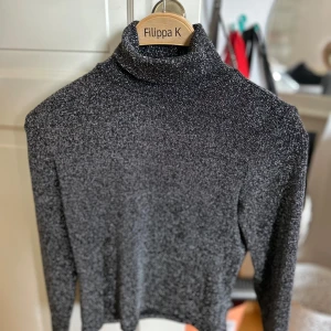 Glittrig polotröja  - Säljer en superfin glittrig polotröja från H&M. Den är perfekt för festliga tillfällen med sin snygga glittriga look. Tröjan har en polokrage och långa ärmar, vilket gör den både stilren och bekväm. Passar perfekt till både jeans och kjol!