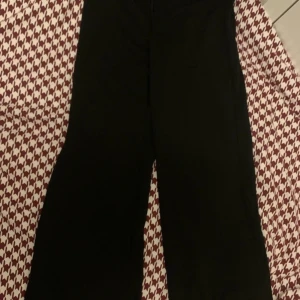 Svarta byxor med knappar - Säljer ett par oanvända  svarta kostymbyxor med knappar i midjan. Perfekta för både vardag och fest! De har en klassisk look och är superbekväma att ha på sig. 