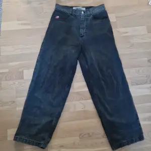 Säljer ett par svart/grå skatejeans från Big Boy i storlek XS. De har en loose fit och är perfekta för en avslappnad stil. Jeansen har klassiska fem fickor och en knappgylf. Skicket är bra förutom lite snyggt slit längst ner baktill. De är redo för en ny ägare!