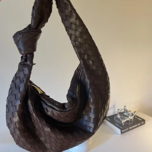 Brun flätad axelväska - Säljer en superfin brun axelväska i flätat mönster. Som ny💕💕 köpt i Köpenhamn och väldigt unik 