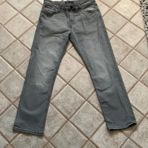 Grå Jeans  - Säljer ett par grå Jeans från Produkt i bra skick. De har en klassisk straight passform och är tillverkade i ett slitstarkt material. Perfekta för både vardag och lite mer avslappnade stunder. Passar bra till höst och vår!
